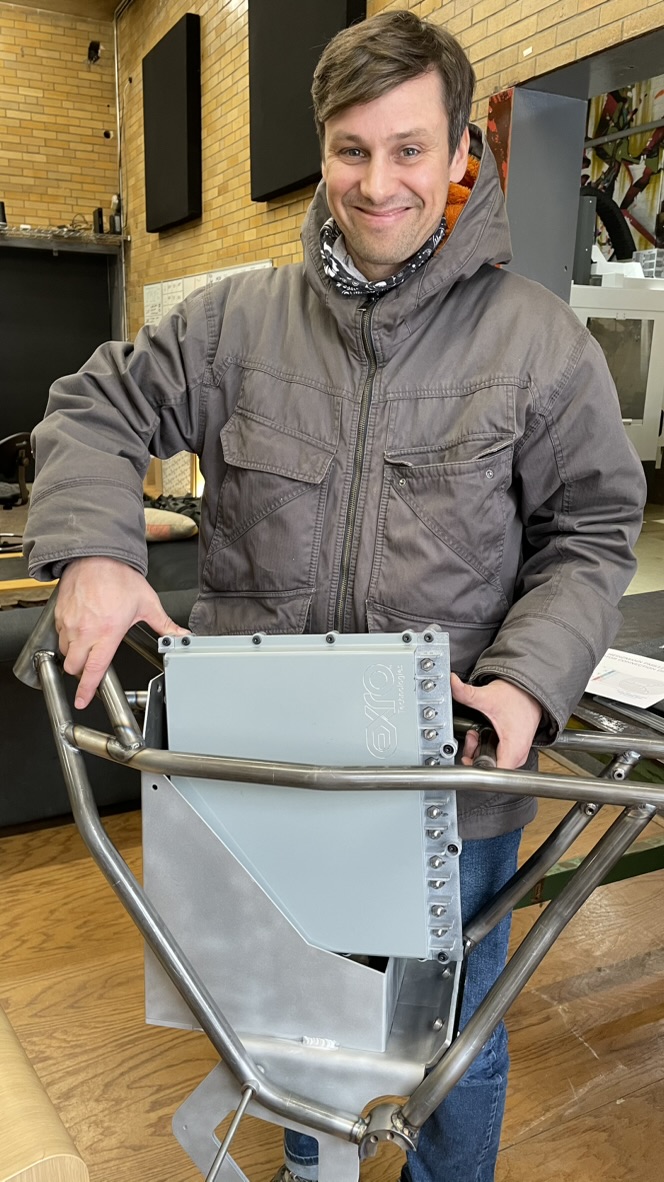 Zack with a prototype frame and battery enclosure in the LAND Labs shop