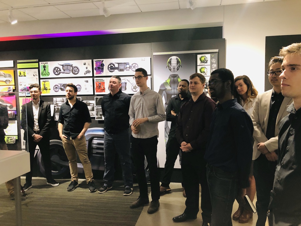 Transportation design class — graduating cohort in front of their work