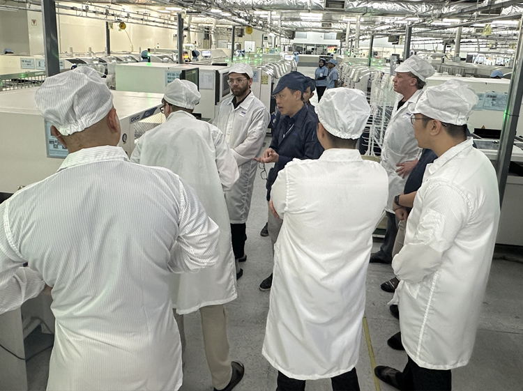 LAND Labs team on an SMT electronics manufacturing line with overseas production partners
